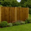 A high-resolution garden scene featuring a fully framed featheredge fence panel in a rich brown finish, set against a lush green lawn with surrounding plants and trees, showcasing a durable and stylish fencing solution for outdoor spaces